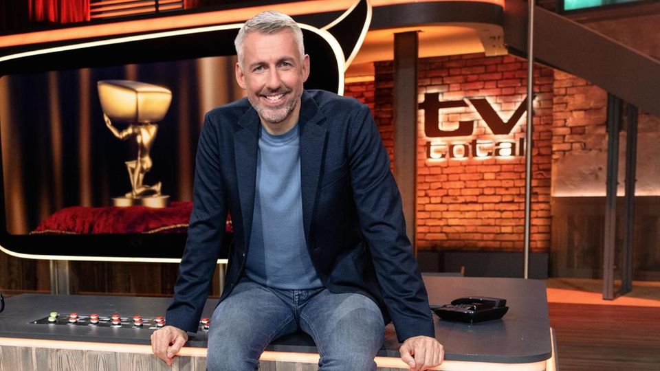 Sebastian Pufpaff sitzt im Tv Total Studio auf dem Tisch