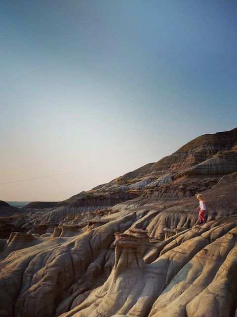 Ein Kleinkind klettert über eine Sandsteinlandschaft in den Badlands