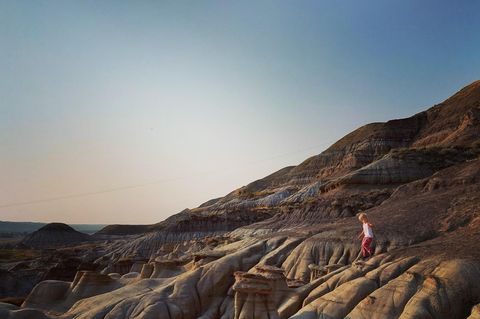 Ein Kleinkind klettert über eine Sandsteinlandschaft in den Badlands