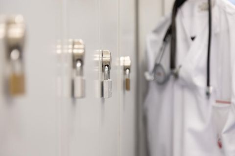 Symbolbild: Arztkittel an einem Spind: England will keine Pubertätsblocker mehr an Kinder ausgeben