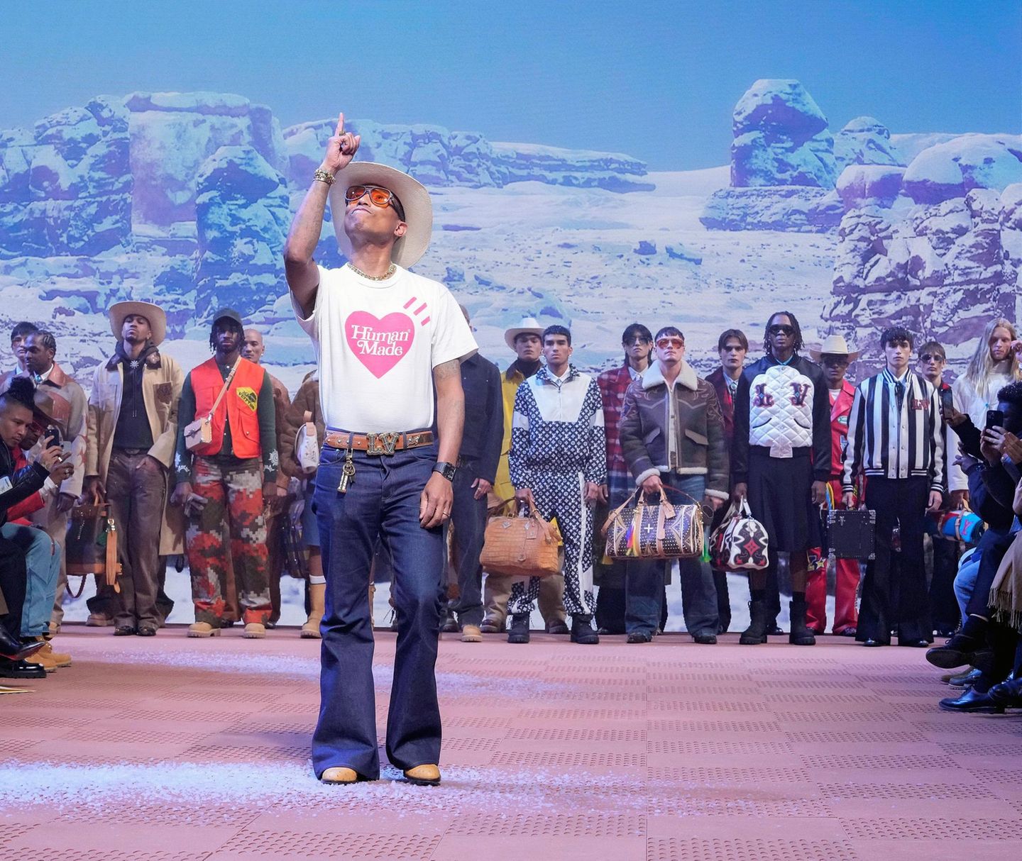 Designer Pharrell Williams mit Cowboy-Hut, im Hintergrund Louis Vuitton-Models