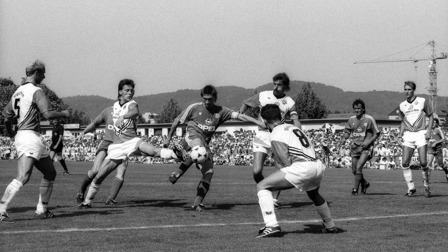 Wir beginnen mit der 1. Runde im DFB-Pokal am 4. August 1990. Die Bayern reisen zum FV 09 Weinheim. Mit Klaus Augenthaler (mitte), Jürgen Kohler oder Stefan Reuter stehen frisch gebackene Weltmeister auf dem Platz. Trainer ist Jupp Heynckes. Doch die Bayern treten arrogant auf und nehmen den Gegner nicht ernst. Das Ergebnis ist eine sensationelle Niederlage gegen den Fünftligisten. Der entscheidende Treffer fällt nach einem Strafstoß.   