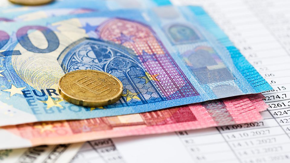 Euroscheine und -Münzen liegen auf einem Abrechnungsdokument