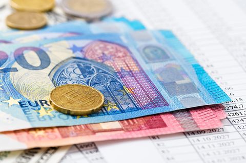 Euroscheine und -Münzen liegen auf einem Abrechnungsdokument