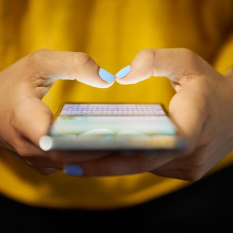Junge Frau tippt in ihr Smartphone
