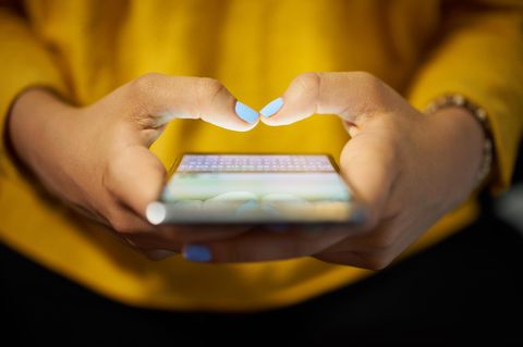 Junge Frau tippt in ihr Smartphone