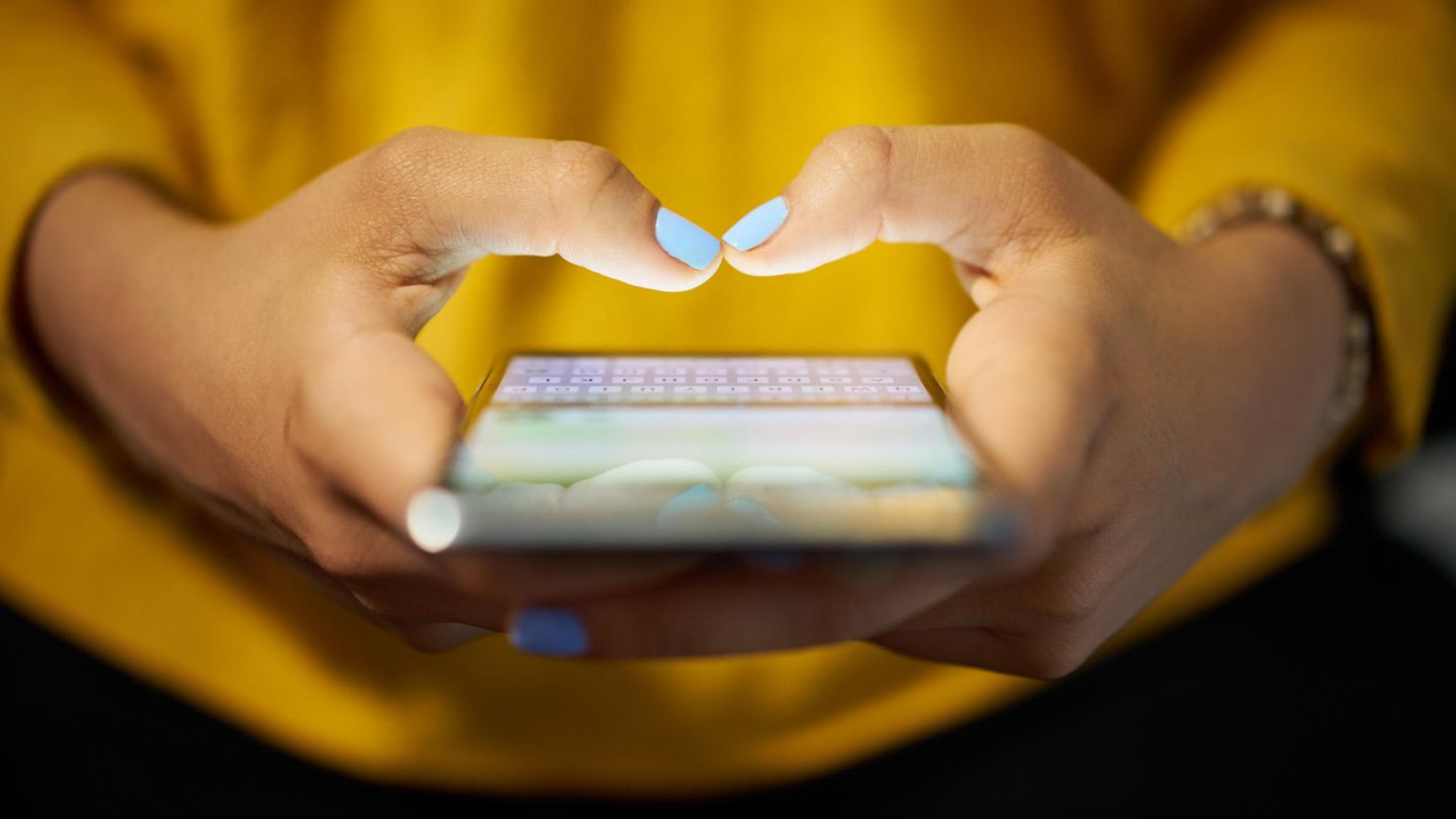 Junge Frau tippt in ihr Smartphone