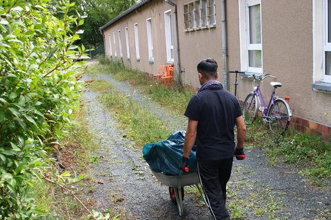 Asylbewerber erledigen Gartenarbeiten im Landkreis Saale-Orla