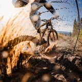 Ein Mountainbike Fahrer verspritzt Schlamm und Wasser