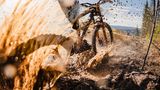 Ein Mountainbike Fahrer verspritzt Schlamm und Wasser