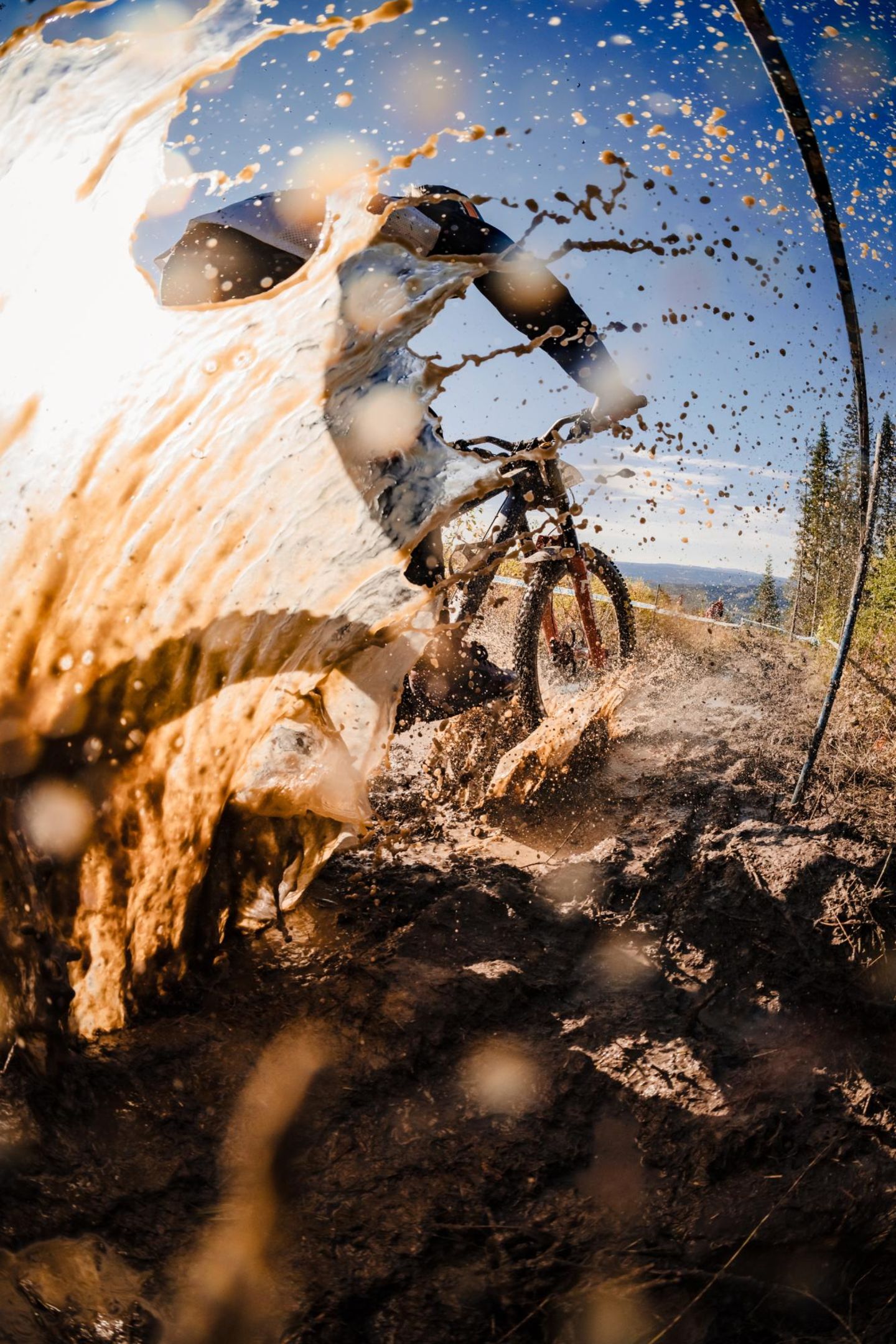 Ein Mountainbike Fahrer verspritzt Schlamm und Wasser