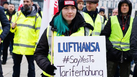 "Lufthansa #SayYesTo Tariferhöhung", fordert eine Mitarbeiterin mit einem Plakat beim Verdi-Streik