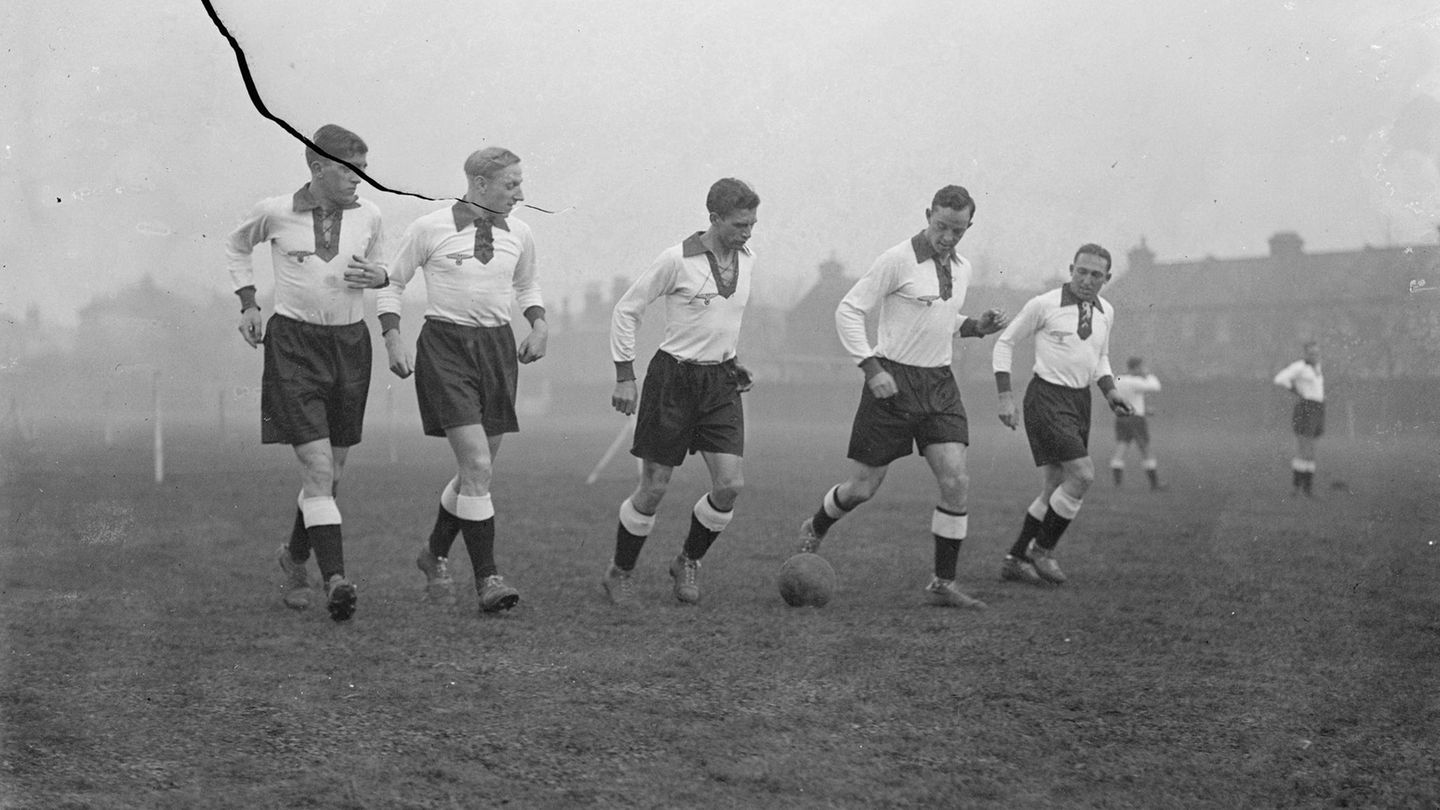 Tiefer V-Ausschnitt und Schnüre Klassisch schwarz-weiß war das Trikot der Deutschen Nationalmannschaft schon immer. Zur WM 1934 kam dann ein optisches Highlight dazu: Der tiefe Ausschnitt konnte geschnürt werden. Einige Spieler ließen ihren Brusthaaren aber lieber freien Lauf, wie etwa Karl Hohmann (Mitte) 1935 vor einem Spiel gegen England.