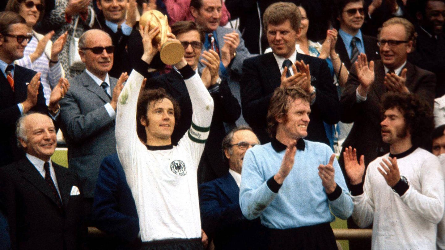 Kein Schnickschnack, aber als Tradition Nach dem ersten WM-Titel änderte sich jahrzehntelang praktisch nichts am Design der DFB-Trikots. Auch beim zweiten Triumph 1974 feierten die Nationalspieler um Franz Beckenbauer (mit Pokal) in schwarz und weiß – einzig der Kragen war noch dezenter geworden.