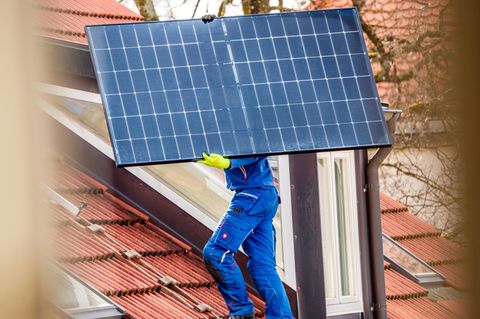 Installation einer Solaranlage auf einem privaten Hausdach in München. Der Ausbau von PV schritt 2023 gut voran, aber noch nicht schnell genug, um die Ausbauziele der Bundesregierung bis 2030 zu schaffen.