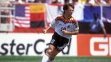 Farbenfroh waren sie ja, die Trikots Anfang der 1990er. Doch bei der WM 1994 in den USA schien irgendetwas allmählich aus dem Ruder zu laufen. Die schwarz-rot-goldenen Elemente nahmen jetzt nicht nur Kragen und Brust ein, sondern waren auch in Richtung Hose gewandert. Lothar Matthäus wirkte vor den bunten Werbebanden fast wie getarnt. Gebracht hat es nichts, im Viertelfinale gegen Bulgarien war Schluss.