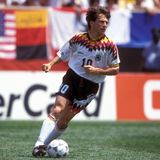 Farbenfroh waren sie ja, die Trikots Anfang der 1990er. Doch bei der WM 1994 in den USA schien irgendetwas allmählich aus dem Ruder zu laufen. Die schwarz-rot-goldenen Elemente nahmen jetzt nicht nur Kragen und Brust ein, sondern waren auch in Richtung Hose gewandert. Lothar Matthäus wirkte vor den bunten Werbebanden fast wie getarnt. Gebracht hat es nichts, im Viertelfinale gegen Bulgarien war Schluss.