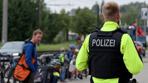 Ein Polizist beobachtet Kinder und Jugendliche vor einer Schule in Mecklenburg-Vorpommern