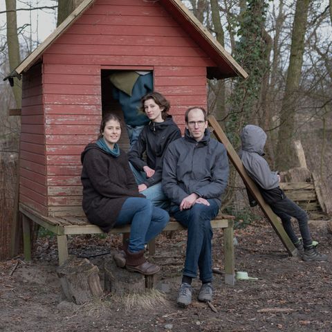 Familie Jacob vor einem kleinen roten Baumhaus