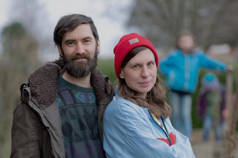 Maike und Simon Werle, Mitglieder bei der Letzten Generation, stehen druaßen, im Hintergrund die Kinder.