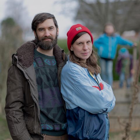 Maike und Simon Werle, Mitglieder bei der Letzten Generation, stehen druaßen, im Hintergrund die Kinder.