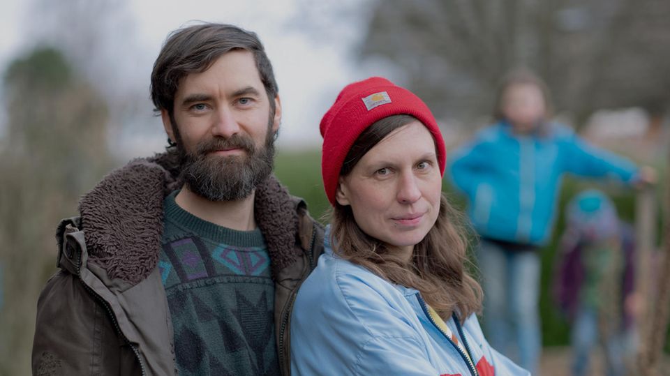 Maike und Simon Werle, Mitglieder der letzten Generation, stehen draußen, im Hintergrund die Kinder.