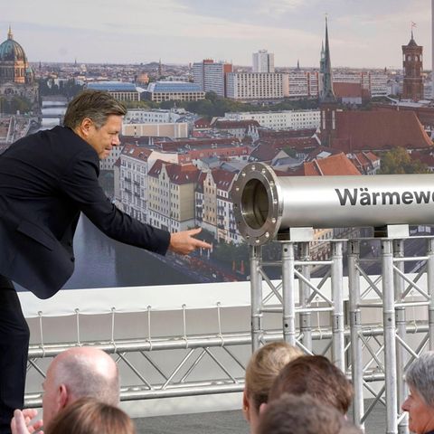 Robert Habeck neben Rohr mit Aufschrift Wärmewende
