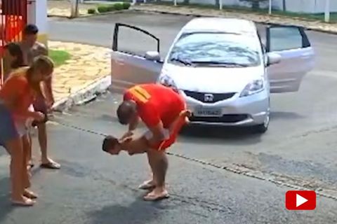 Ein Junge wird von einem Feuerwehrmann in die Luft gehalten, während dieser ihm auf den Rücken klopft