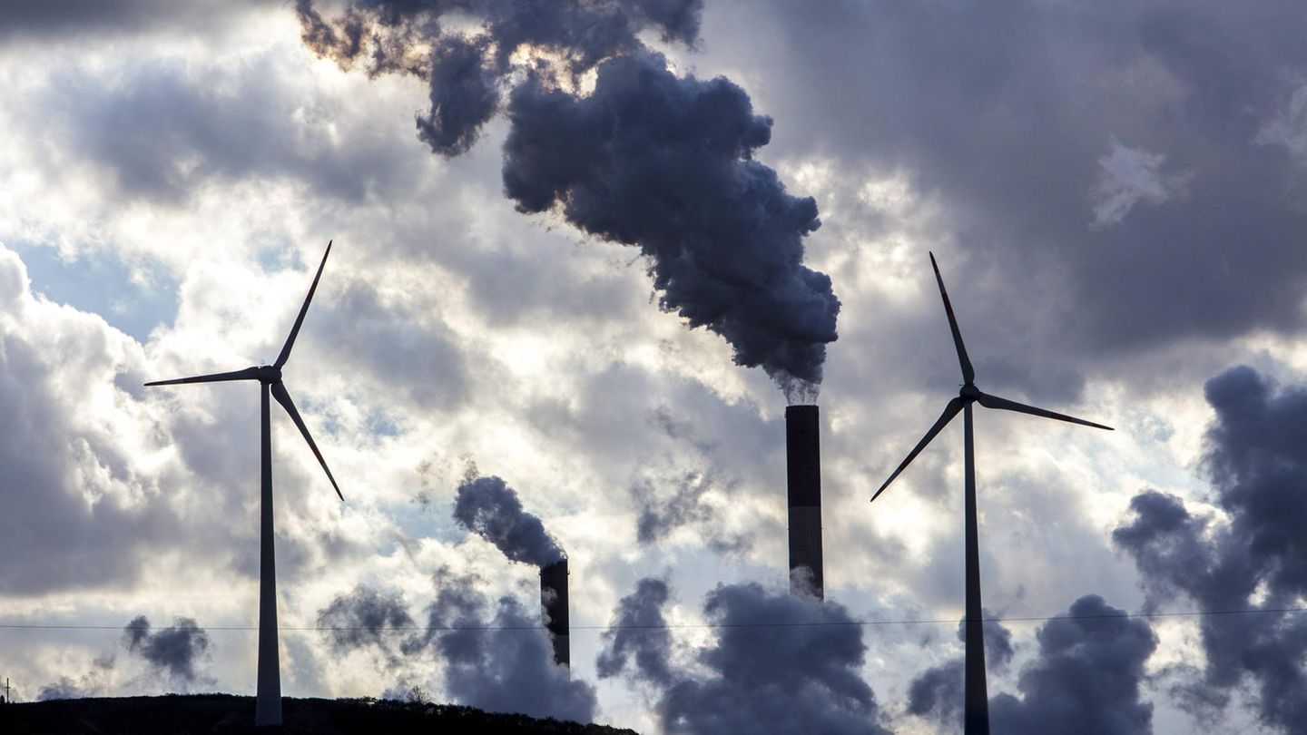 Windenergieanlagen neben rauchenden Schornsteinen