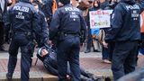 Berlin, Deutschland. Drei Polizisten umzingeln einen Klimaaktivisten, während ein vierter Kollege den Mann an der Jacke von der Straße zerrt. Bilder wie dieses sind altbekannt, wurden zuletzt aber seltener, weil sich die Letzte Generation vor ihrem Strategiewechsel zurückgezogen hatte. Nun ist sie aber zurück auf den Straßen – zumindest heute protestierten ihre Mitstreiter in zehn Städten, darunter Berlin, Rügen und Bremen.