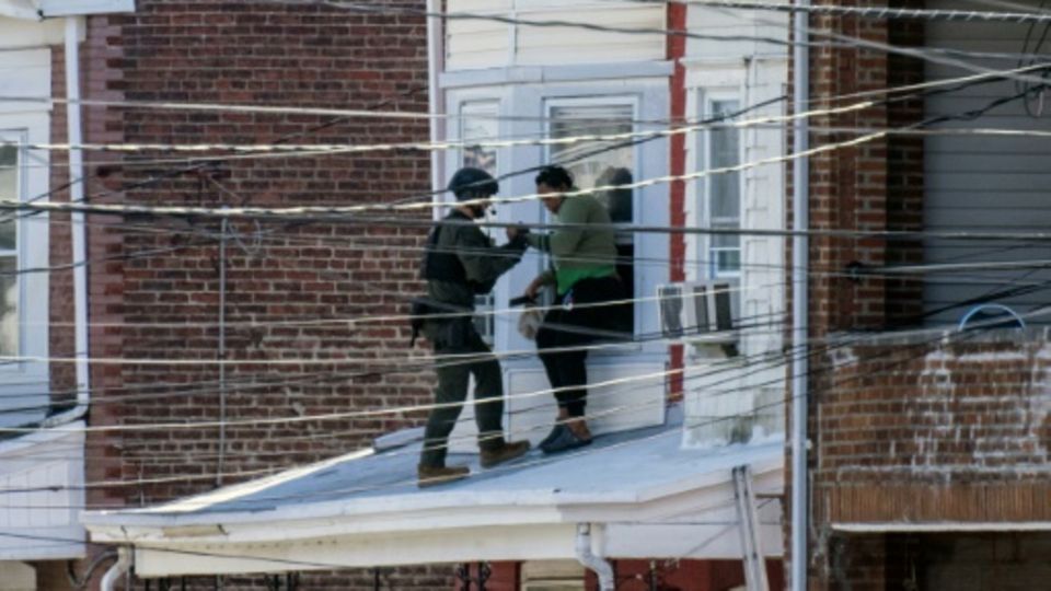 Police evacuate residents from a home in Trenton, New Jersey, where a suspect was believed to be holed up after allegedly killin