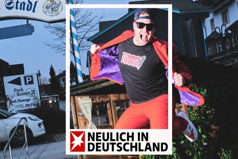 Ein Mann im roten Anzug und Sonnenbrille und Mütze springt in die Luft