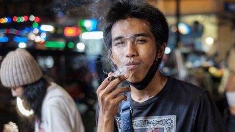Ein Mann raucht einen Joint in Bangkok