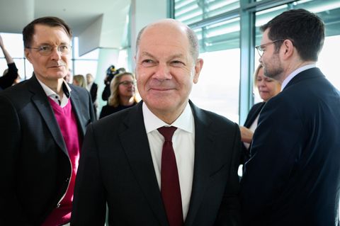 Kanzler Olaf Scholz lächelnd im Bundeskabinett, hinter ihm Gesundheitsminister Lauterbach und Justizminister Buschmann