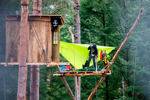 Eine Person seilt sich von einem Baumhaus im Protestcamp zwischen Grünheide und der Tesla-Fabrik ab