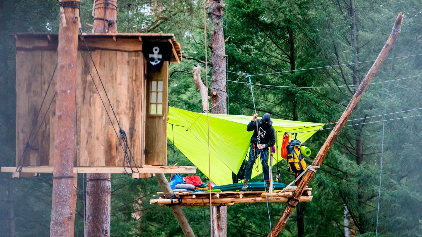 Eine Person seilt sich von einem Baumhaus im Protestcamp zwischen Grünheide und der Tesla-Fabrik ab