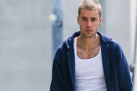 Justin Bieber geht mit einem Smartphone in der Hand die Straße entlang
