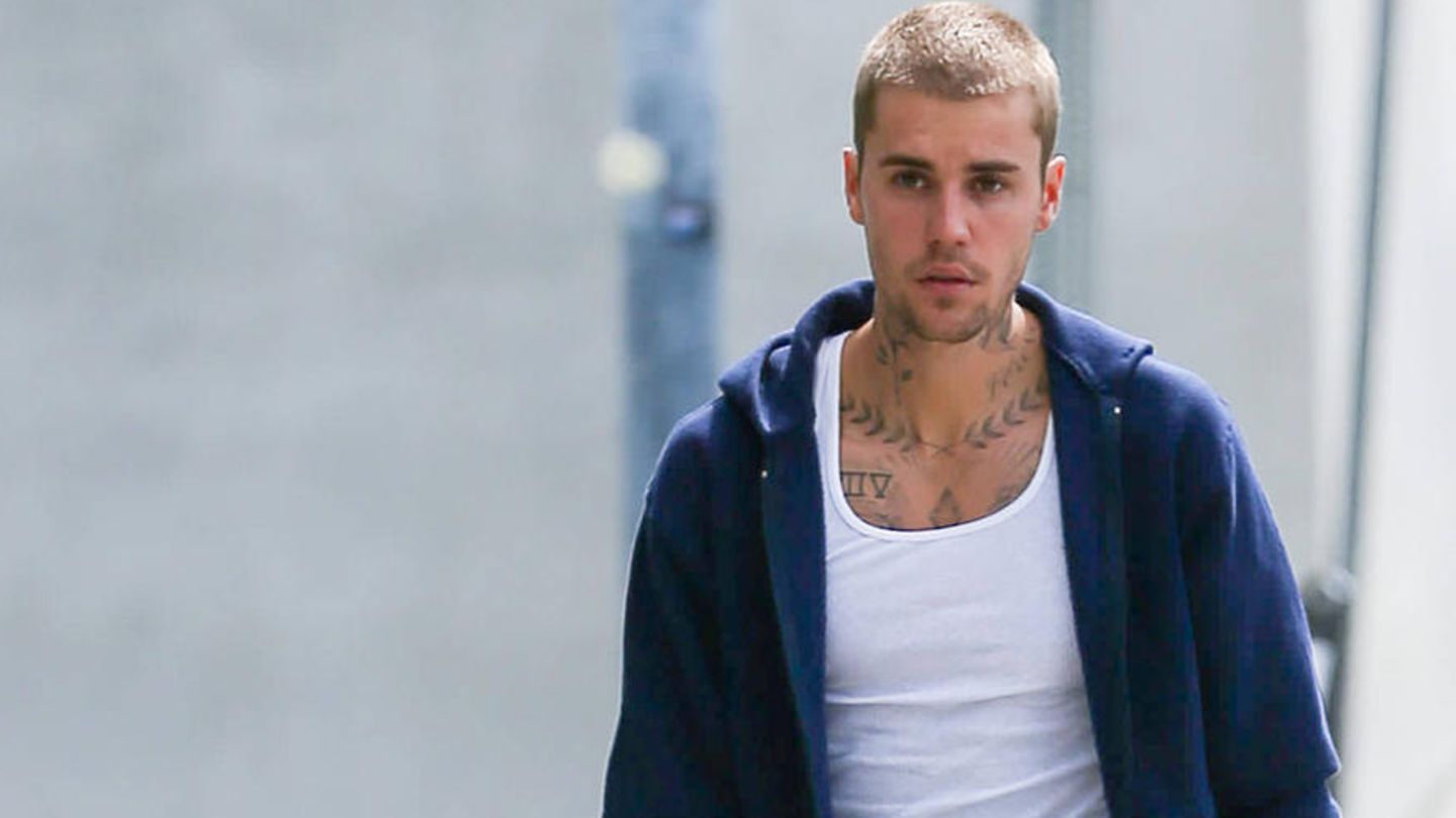 Justin Bieber geht mit einem Smartphone in der Hand die Straße entlang