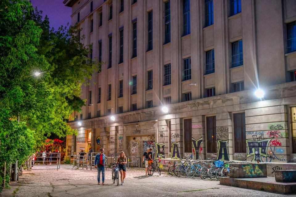 Vor dem Berghain in Berlin laufen nachts Personen und machen sich auf den Heimweg