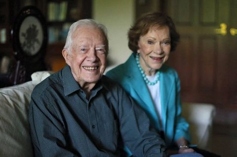 Jimmy und Rosalynn Carter sitzen auf einem Sofa und lächeln in die Kamera