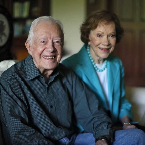 Jimmy und Rosalynn Carter sitzen auf einem Sofa und lächeln in die Kamera