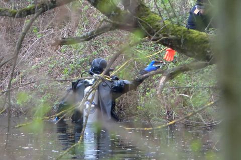 Ein Taucher der Polizei sucht in einem Gewässer nach der Leiche einer mutmaßlich getöteten Frau