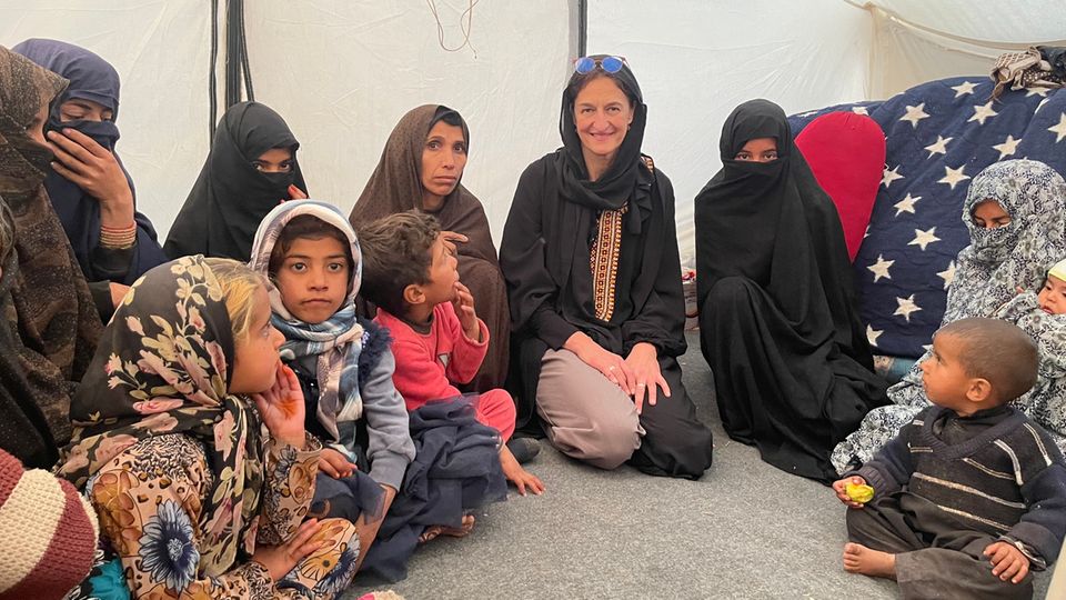 Christina Ihle in the tent Development worker Christina Ihle kneels in the tent next to Afghan children and family members.