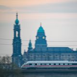 Sachsen, Dresden: Ein ICE der Deutschen Bahn fährt am Morgen vor der Altstadtkulisse über die Marienbrücke