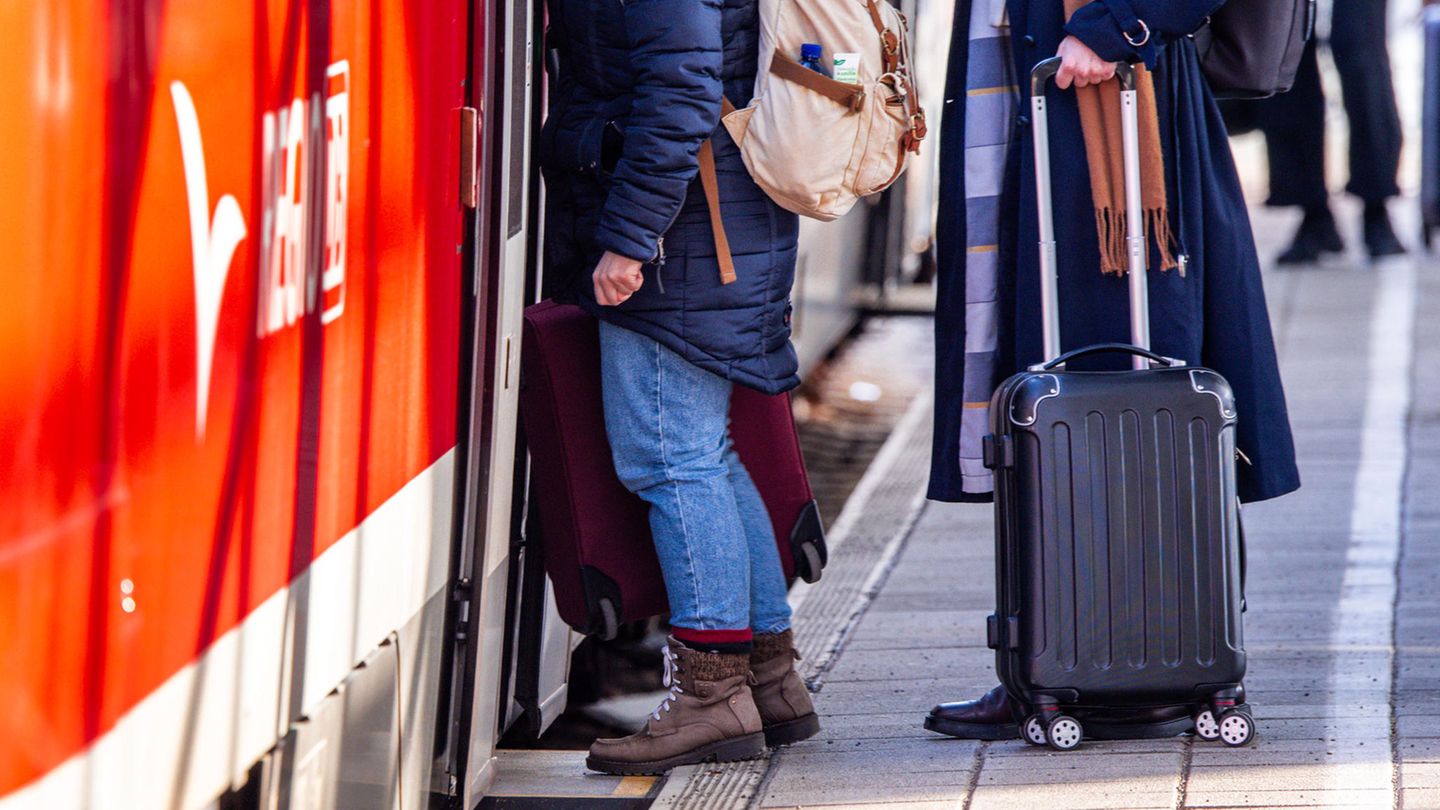 Deutsche Bahn: Wismar: Passagiere mit Koffern steigen im Bahnhof in eine Regionalbahn nach Rostock ein