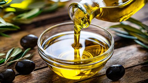 Olivenöl wird in eine Schale gegossen