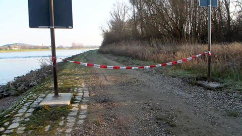 Ein Weg am Rhein bei Hockenheim ist mit Flatterband der Polizei abgesperrt