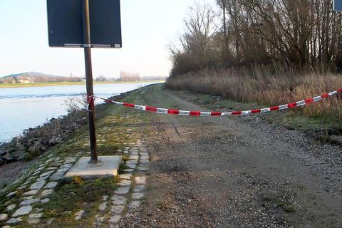 Ein Weg am Rhein bei Hockenheim ist mit Flatterband der Polizei abgesperrt