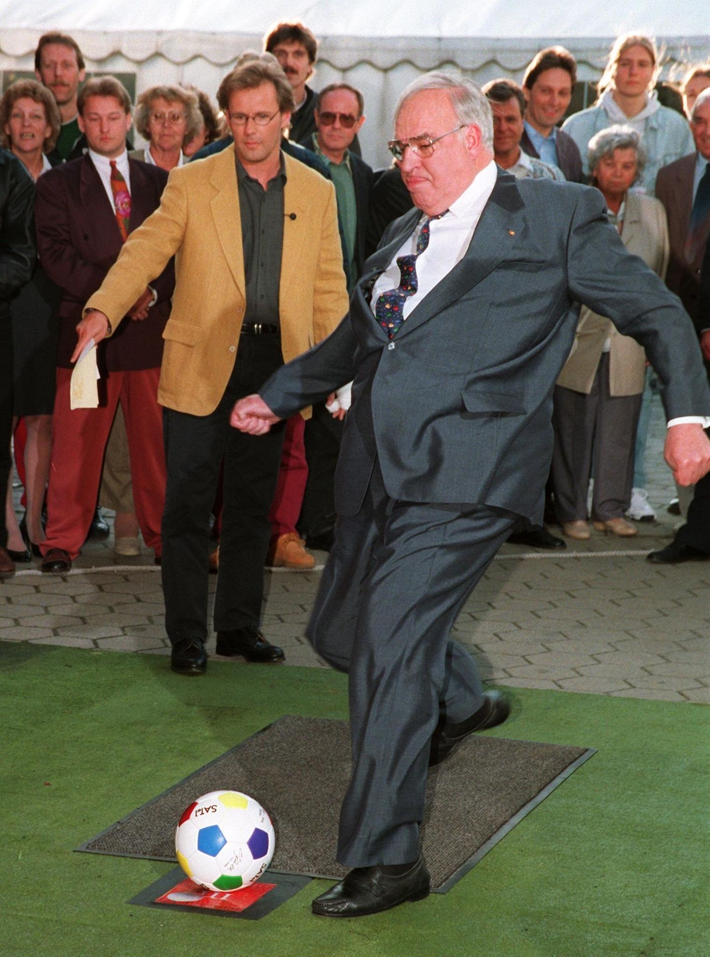 Helmut Kohl vor einer Torwand schießt einen Fussball