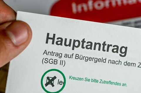 Nahaufnahme eines Antrags auf Bürgergeld, den eine Hand festhält